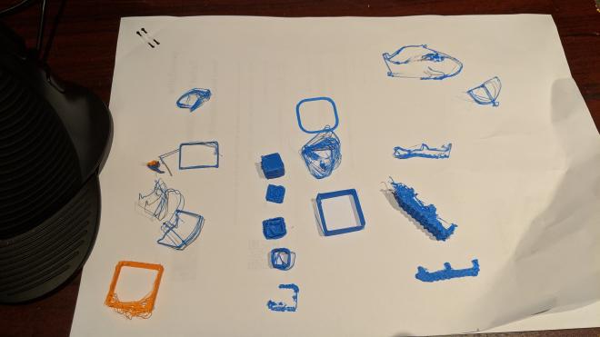 A piece of white paper proudly displays some semi-molten blobs of blue and orange plastic